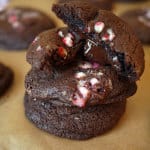 Piled up chocolate candy cane cookies, with one halved with a melting middle.