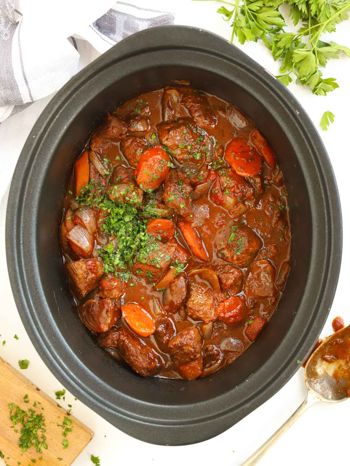 A Beef Stifado Greek-style beef stew with vegetables in a slow cooker pan, ready to be served.