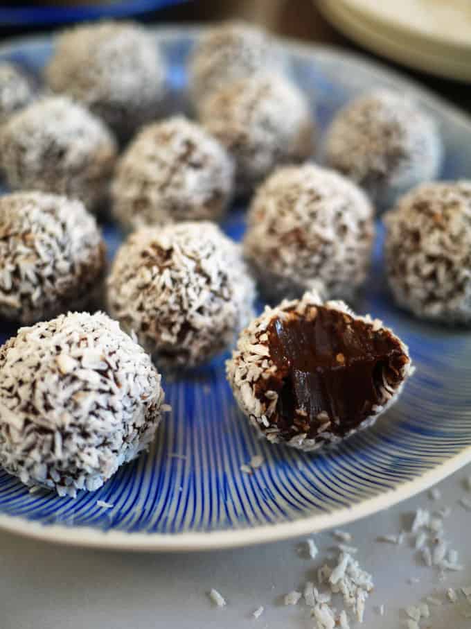 A close up of homemade chocolate truffles, one with a bite taken out.