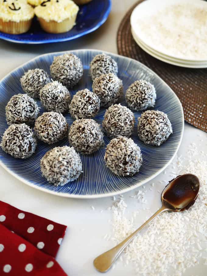 A plate of homemade chocolate truffles, covered in desiccated coconut.
