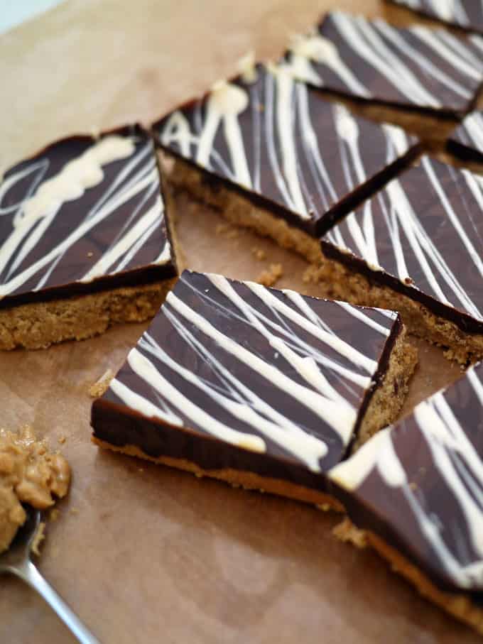 Squares of peanut butter bars topped with chocolate.