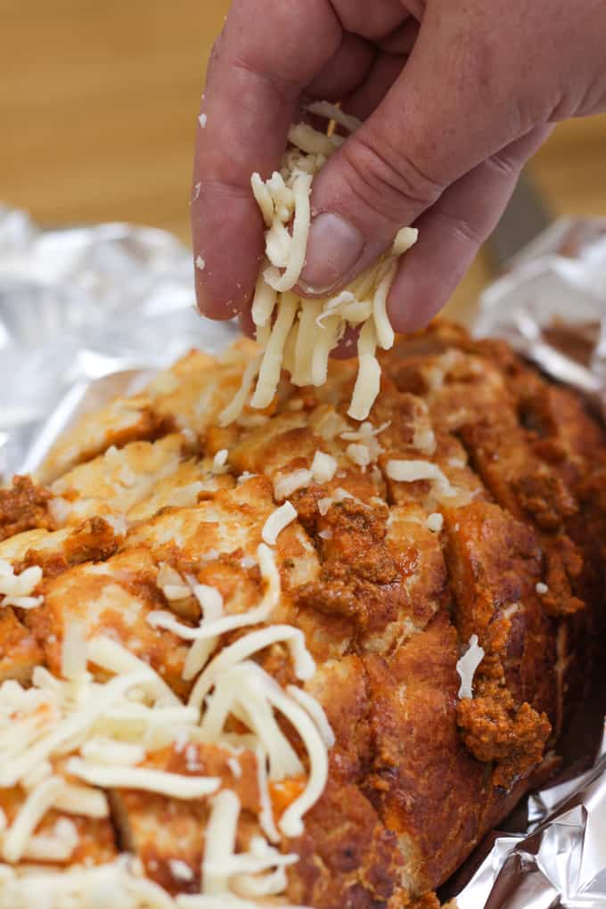 Cheesy Pesto Garlic Pull Apart Bread - A cheese filled treat. The perfect side dish for dinner or snacking. Pesto adds a depth of flavour to this pull apart bread with the mountains of melting mozzarella cheese.
