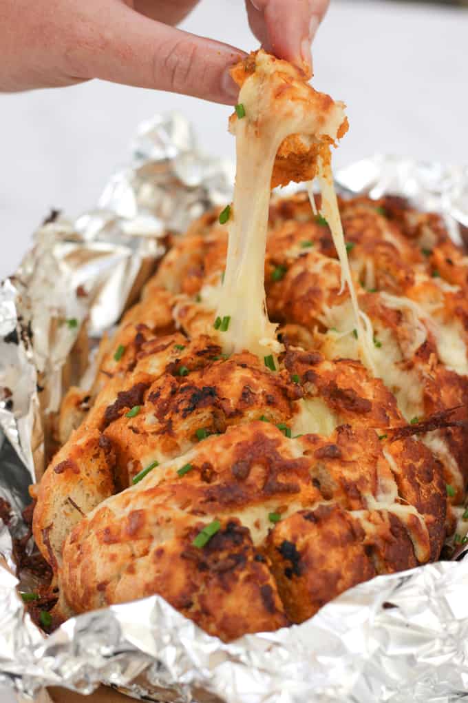 Cheesy Pesto Garlic Pull Apart Bread - A cheese filled treat. The perfect side dish for dinner or snacking. Pesto adds a depth of flavour to this pull apart bread with the mountains of melting mozzarella cheese.