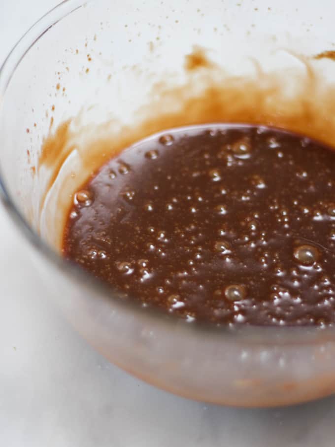 Glass bowl of melted milk chocolate with butter and golden syrup for cornflake cake Easter nest.