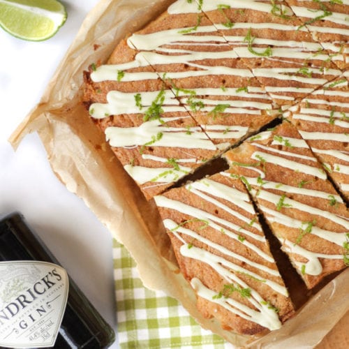 These Gin and Tonic Cake Bars are super simple and delicious. An easy cake packed with gin and tonic flavour, with zesty lime and a crunchy glaze. Based on a lemon drizzle cake style recipe, with gin infused syrup and topped with white chocolate. #ginandtonic #cakerecipe #easydessert #tamingtwins