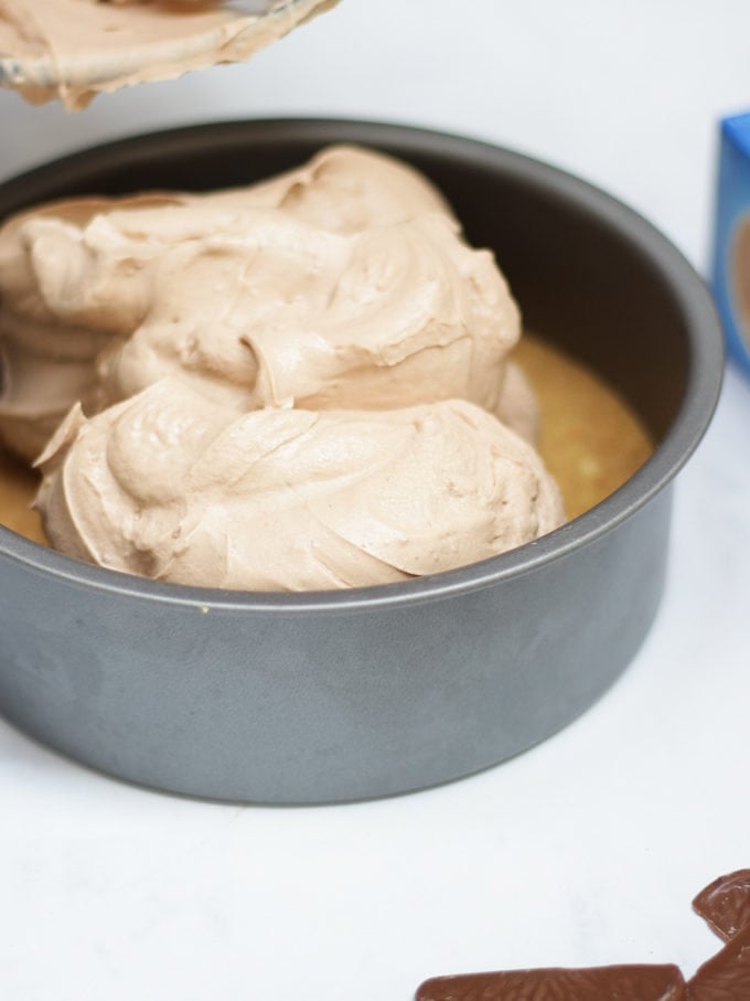 Photo of metal tin with chocolate orange cheesecake recipe filling going on top of a biscuit base.