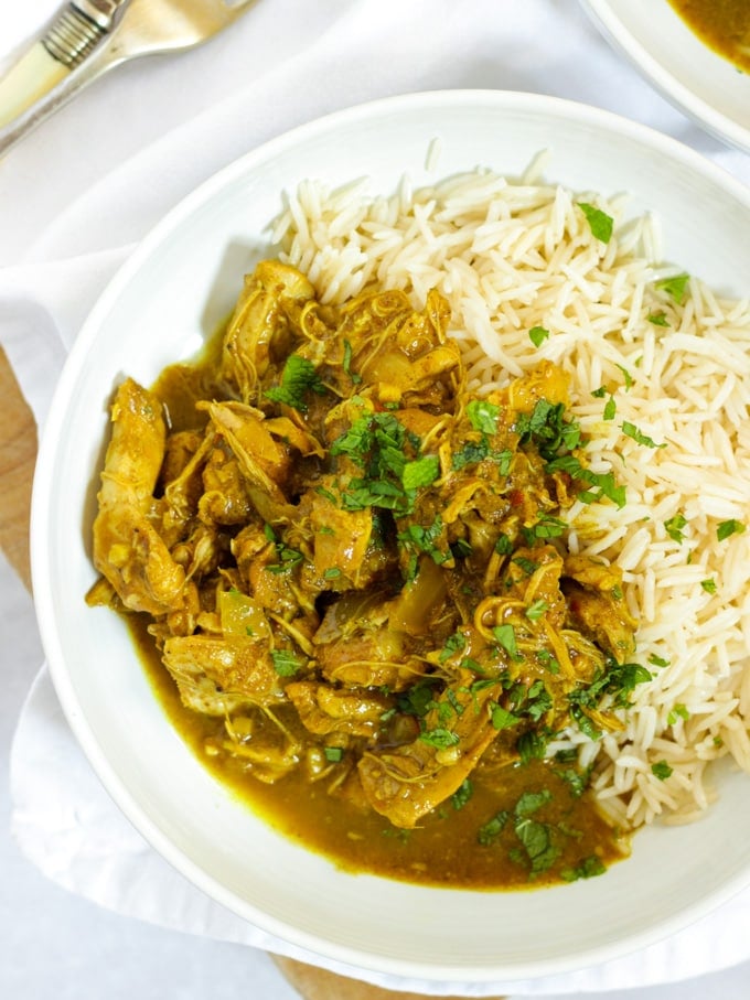 Easy slow cooker chicken curry in bowls with rice sprinkled with mint