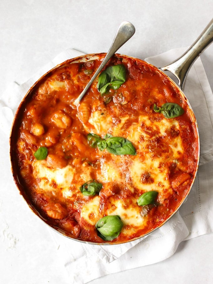 Pan of healthy baked gnocchi in tomato sauce topped with cheese.