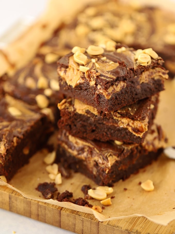 Piled brownie squares topped with peanuts.
