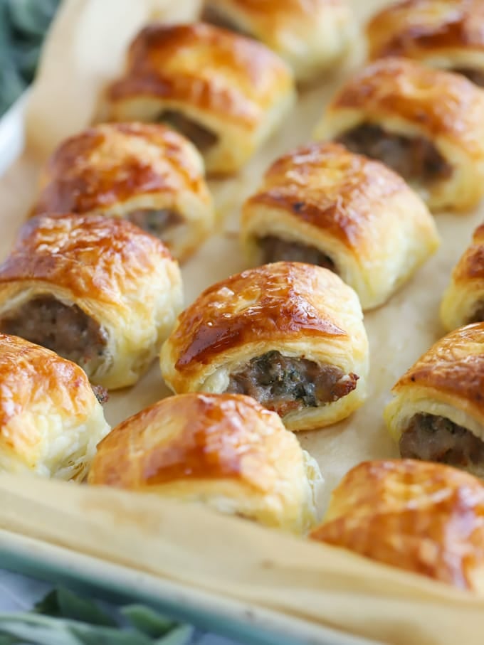 Golden, flaky rows of sausage rolls on a baking tray.