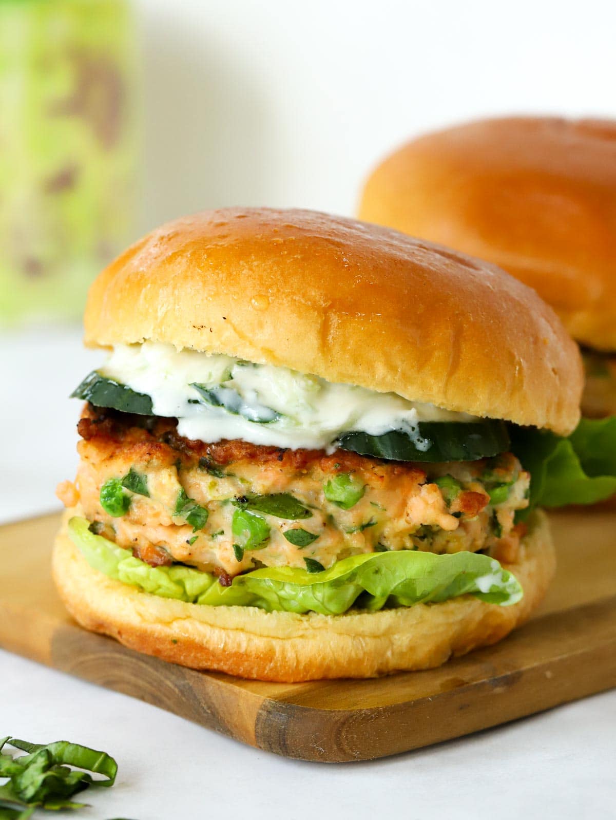 Side view of a Salmon Burger in a bap with salad.