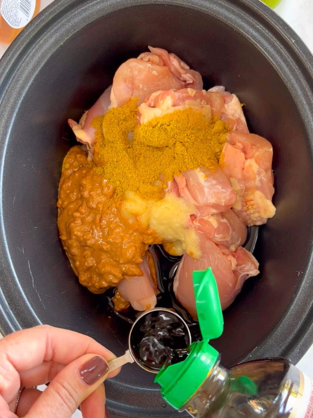 Step 1 in the recipe for Slow Cooker Chicken Satay. Add ingredients to the pan.