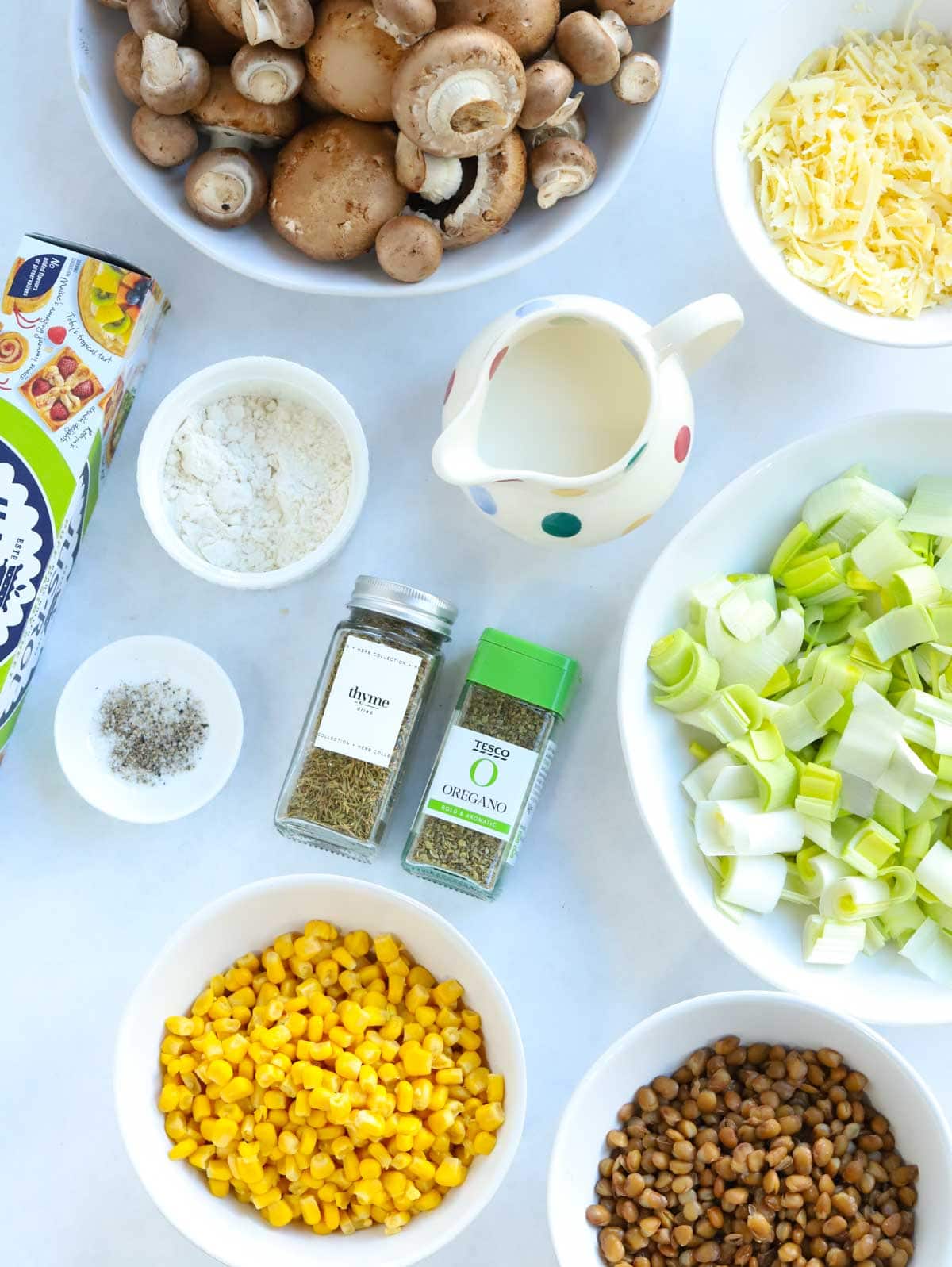 The ingredients for a cheesy vegetarian pie laid out on a counter.