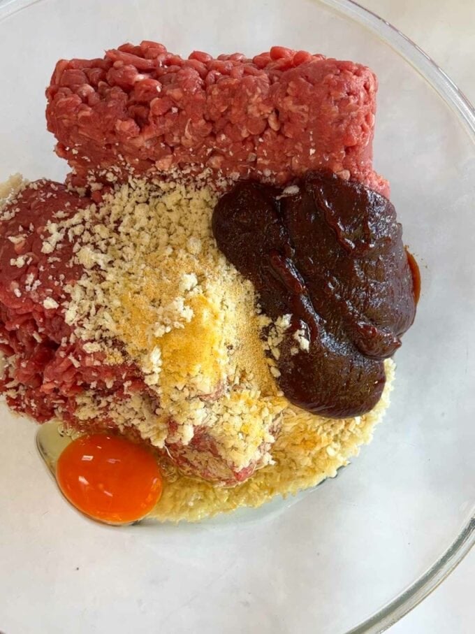 Raw ingredients in a bowl for an easy meatloaf recipe step 1.
