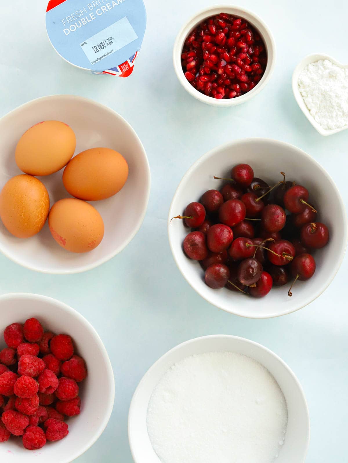 Ingredients for a Christmas Wreath Pavlova recipe laid out on a counter.