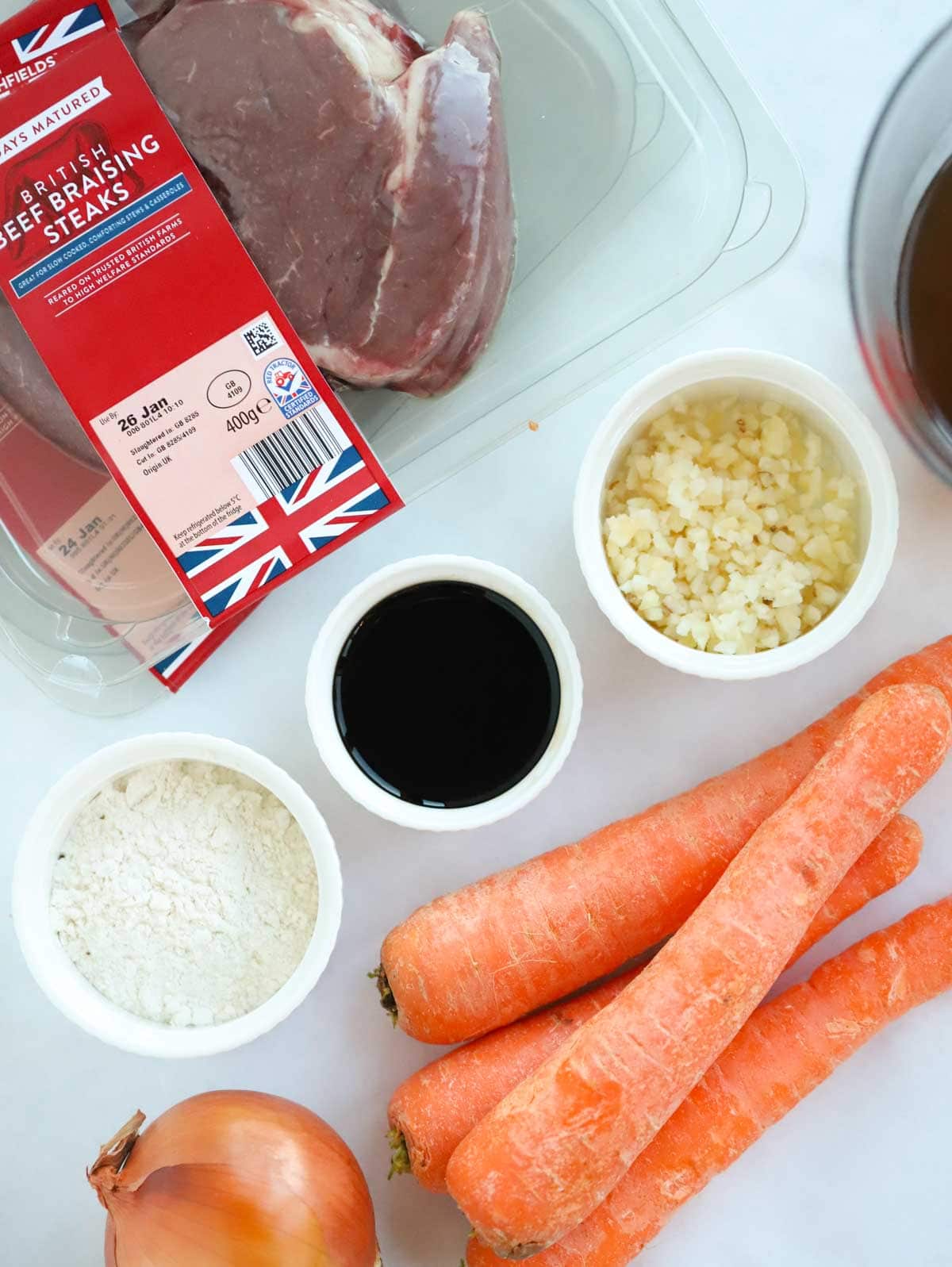 Ingredients for a braised steak meal laid on a counter.