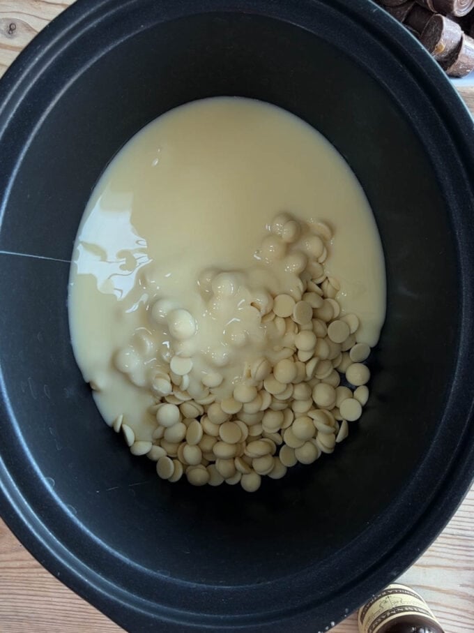 A slow cooker with white chocolate and condensed milk. Rolo Fudge recipe. Step 1.