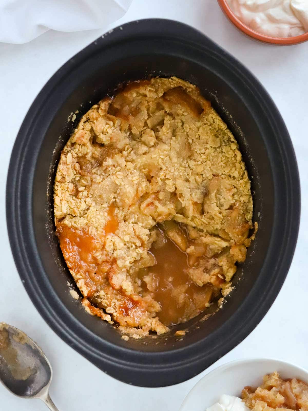 A slow cooker with Apple Crumble cooked inside.