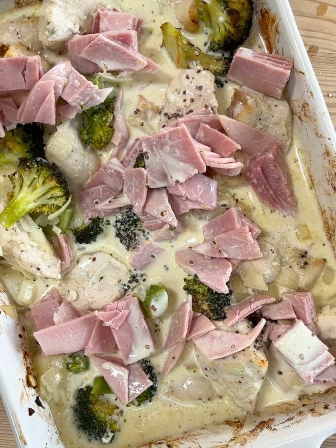 The sauce of a pie in an oven dish, with ham, broccoli and chicken.