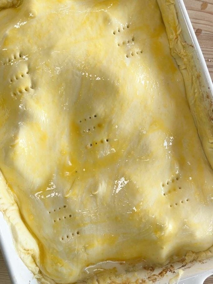 Pastry over a pie, with holes in, ready to go in the oven.