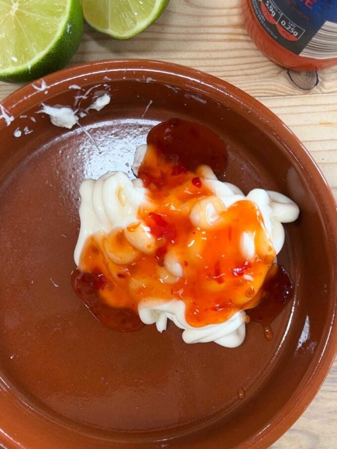 A brown dish with mayonnaise and sweet chilli sauce, yet to be mixed together.