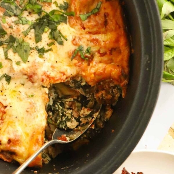 Spinach and ricotta lasagne being spooned out of the slow cooker.