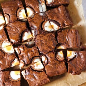 A board with cut up chocolate Creme Egg Brownies on, ready to be served.