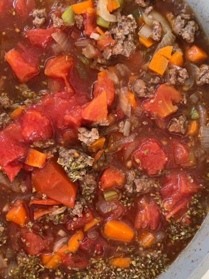 Tomatoes, carrots, mince beef, cooking in a pan together.