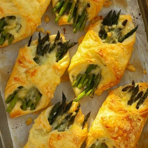Cheese and asparagus wrapped in a puff pastry parcels. Golden brown and straight out of the oven.