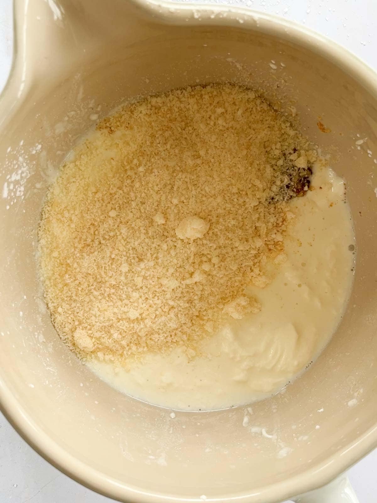 Parmesan and milk in a jug, not yet mixed.