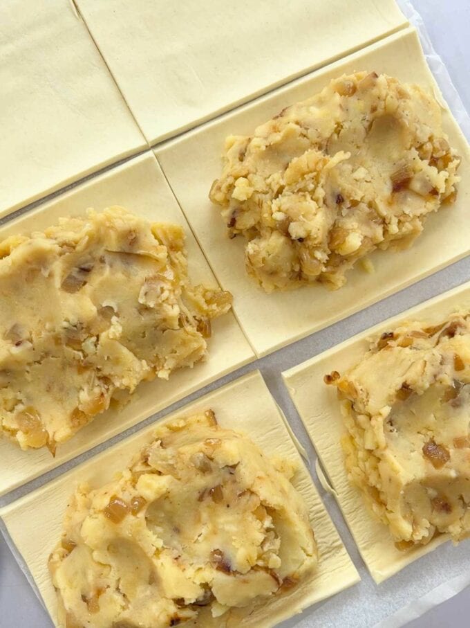 Puff pastry sheets cut into 8 rectangles with a cheese and onion filling in 4.