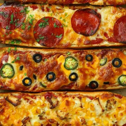 Strips of French bread pizza lined up on a baking tray, after being cooked in the oven.