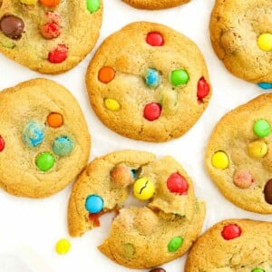 A batch of cookies filled with M&Ms on a white background, ready to eat.
