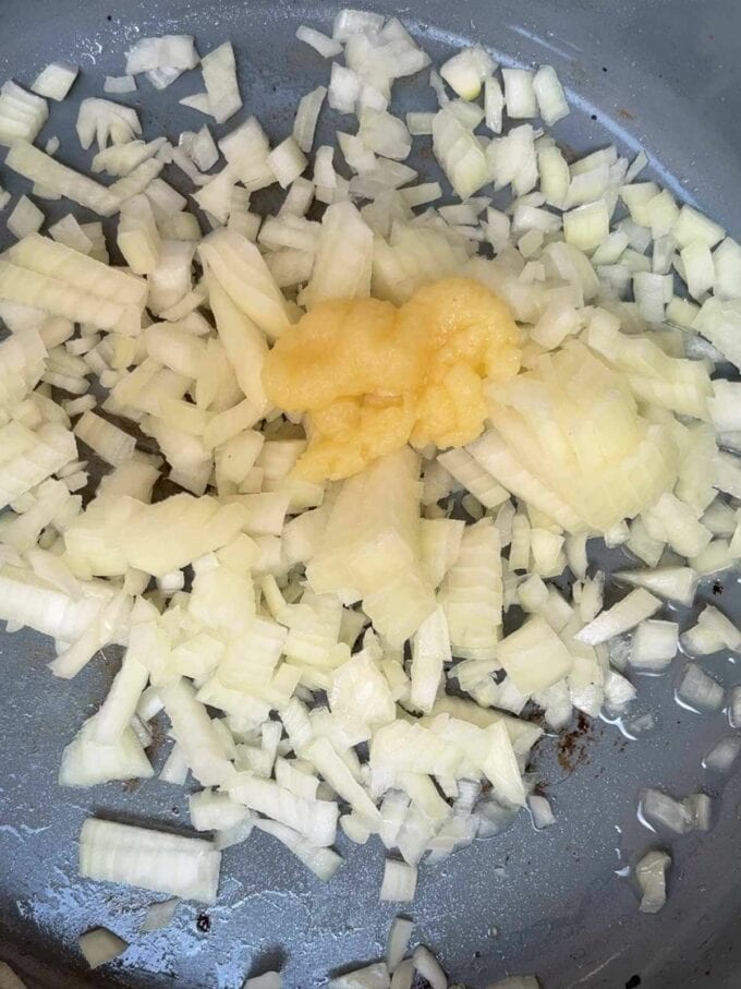 Onions and garlic frying in a pan.