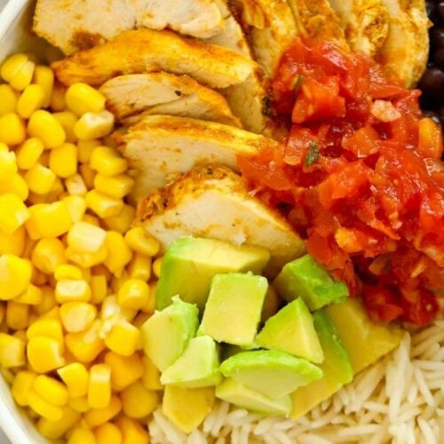 A close up of a bowl of rice, avocado, sweetcorn, salsa and chicken.