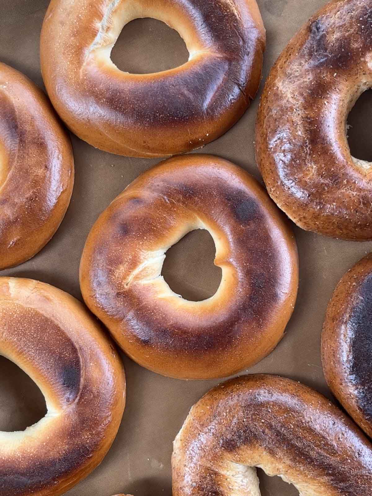Step 2 of making tuna melt bagels. Bagels on a board.
