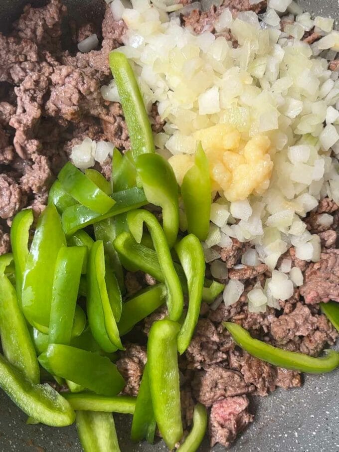 A pan with mince, onion and peppers cooking.