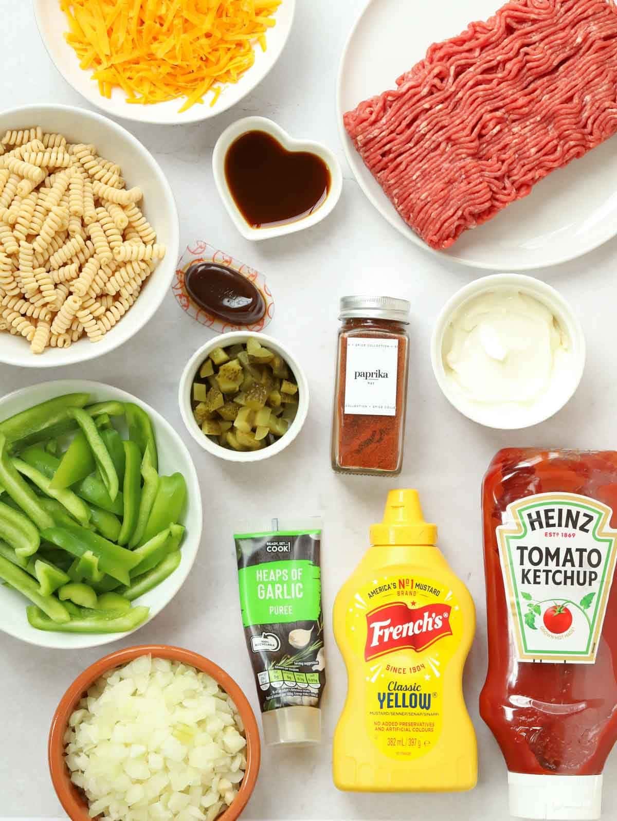 Ingredients laid out on a counter, including cheese, pasta and beef mince.