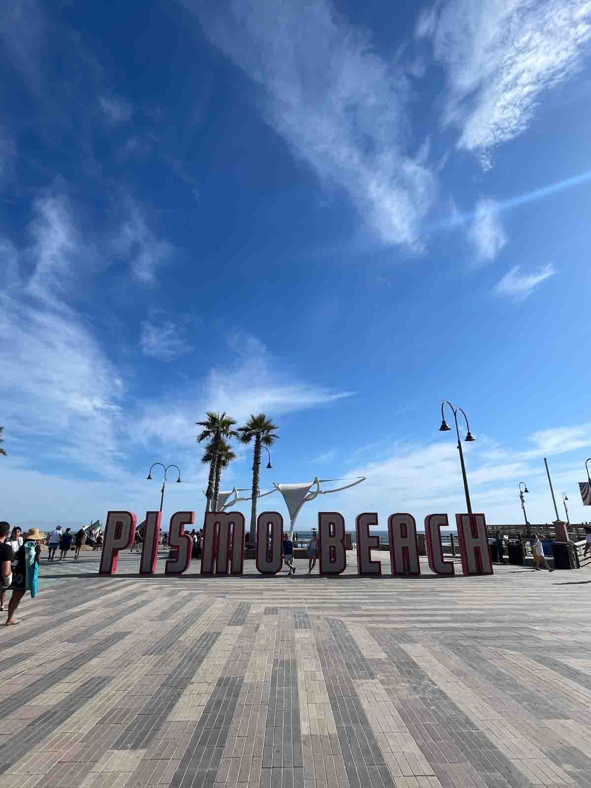 Pismo beach sign with children in front.