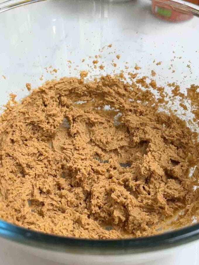 Brown sugar and butter whisked together in a glass bowl for step 1 in the recipe Pumpkin Cake.