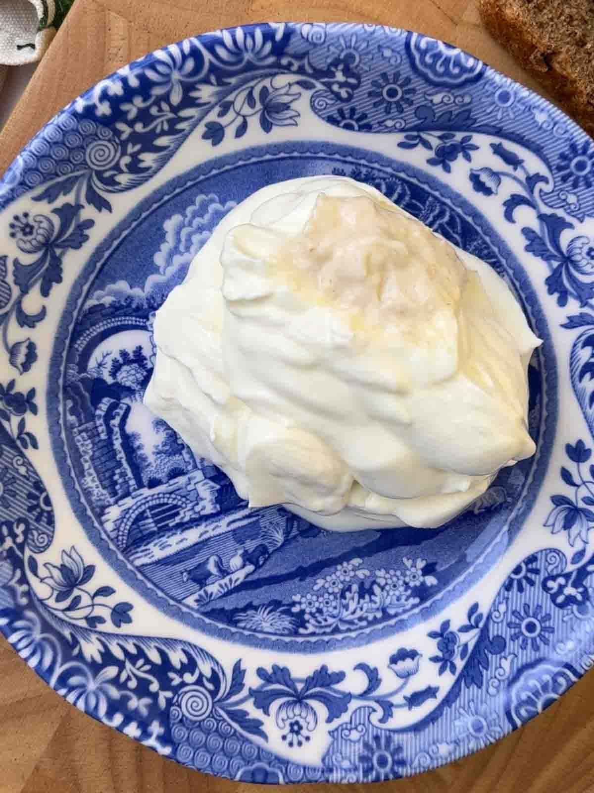 Creme fraiche in a bowl to put on top of Smoked Salmon Canapes.