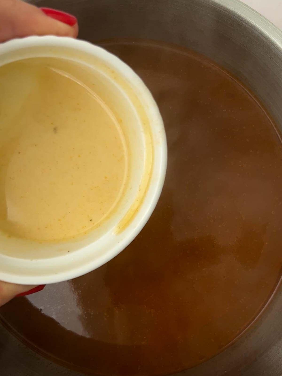 A cornflour paste about to be poured into a pan of vegetarian gravy.