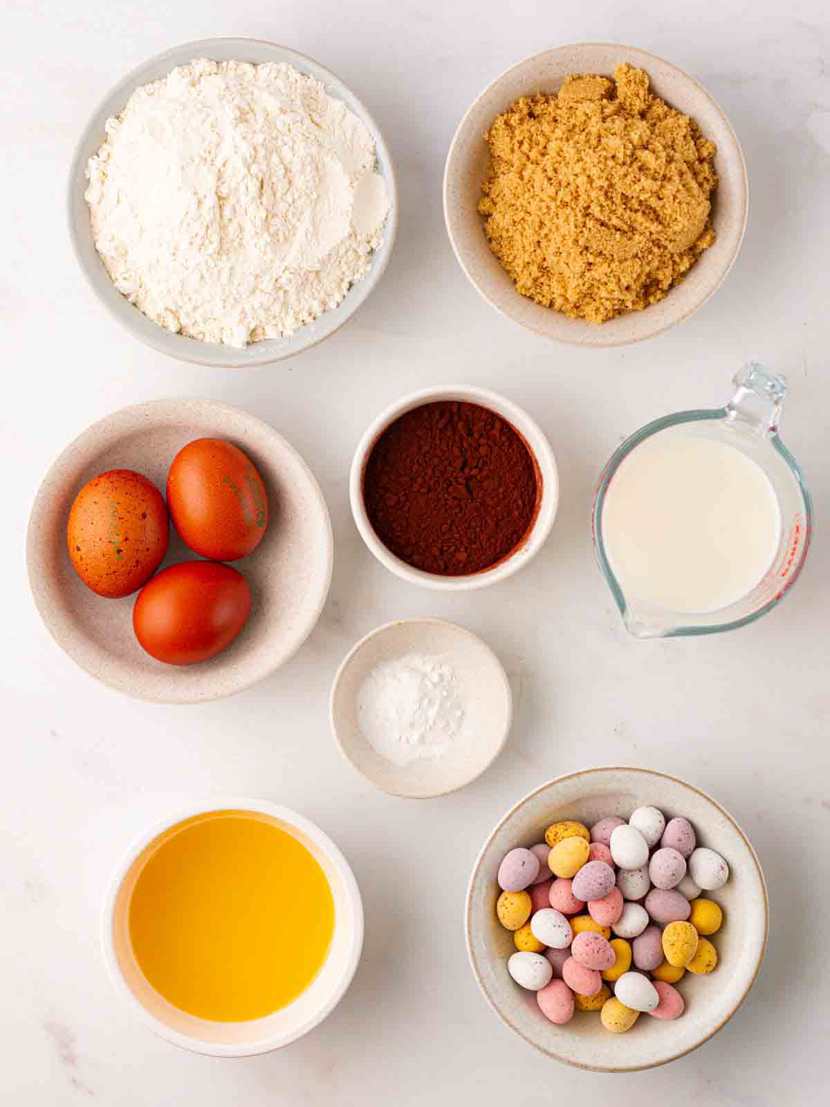 The ingredients for slow cooker mini egg easter pudding laid out on a counter top.