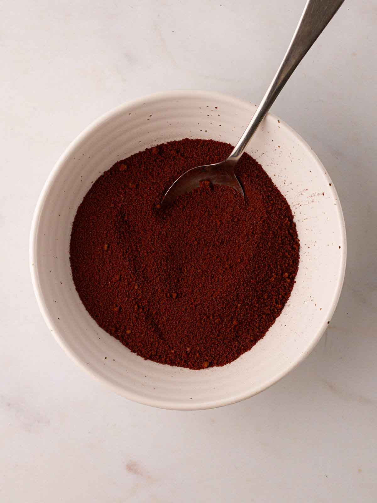 A bowl with cocoa mixture in for step 3 in the recipe for Slow Cooker Mini Egg Easter Pudding.