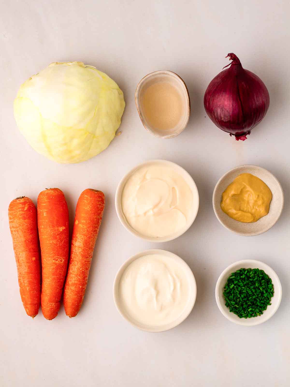 The ingredients for homemade coleslaw laid out on a counter top.