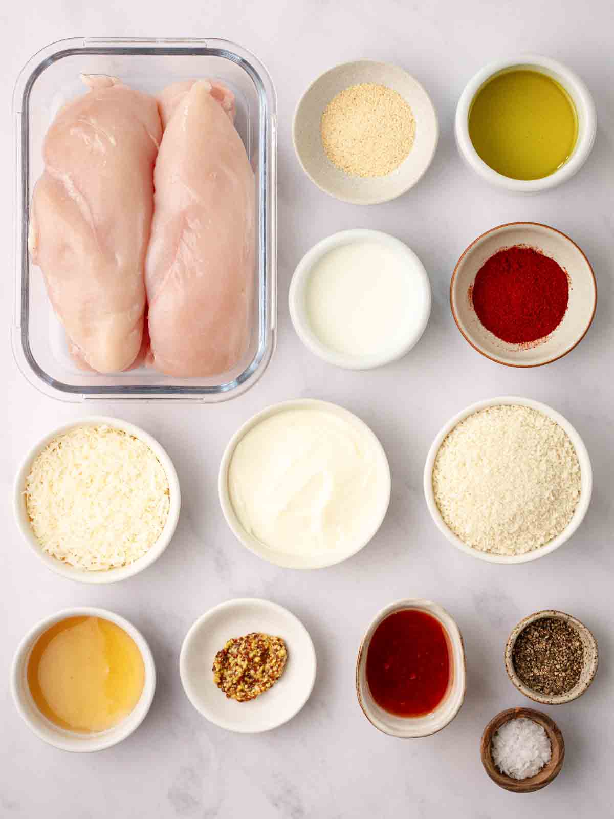 The ingredients for homemade chicken nuggets laid out on a counter top.