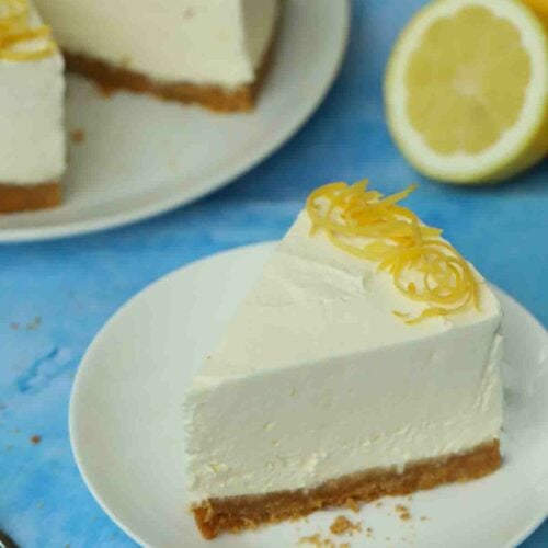 A no bake lemon cheesecake made with Philadelphia with a slice missing, which is on a plate.