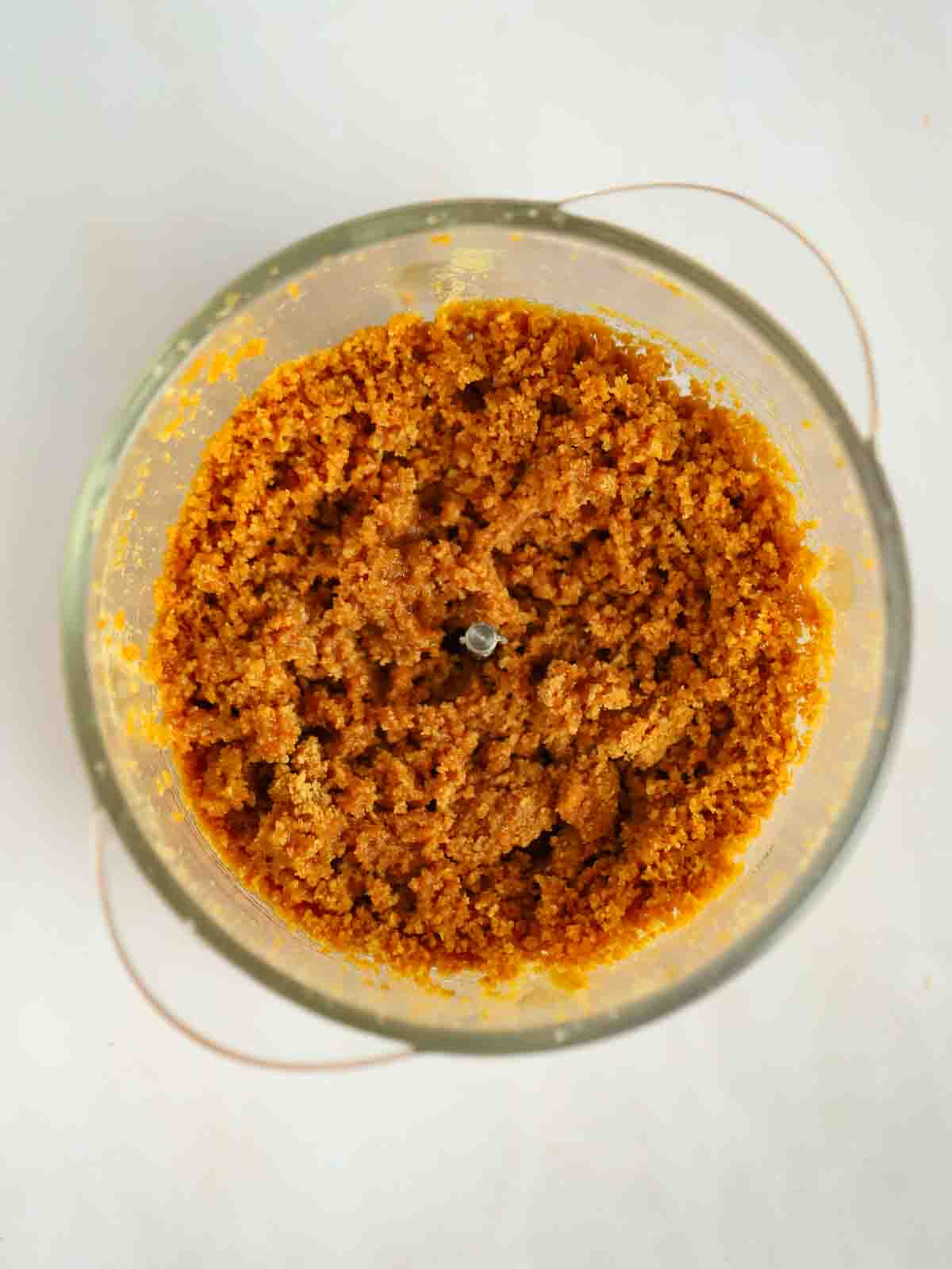 Crushed ginger biscuits in the bottom of a processor.