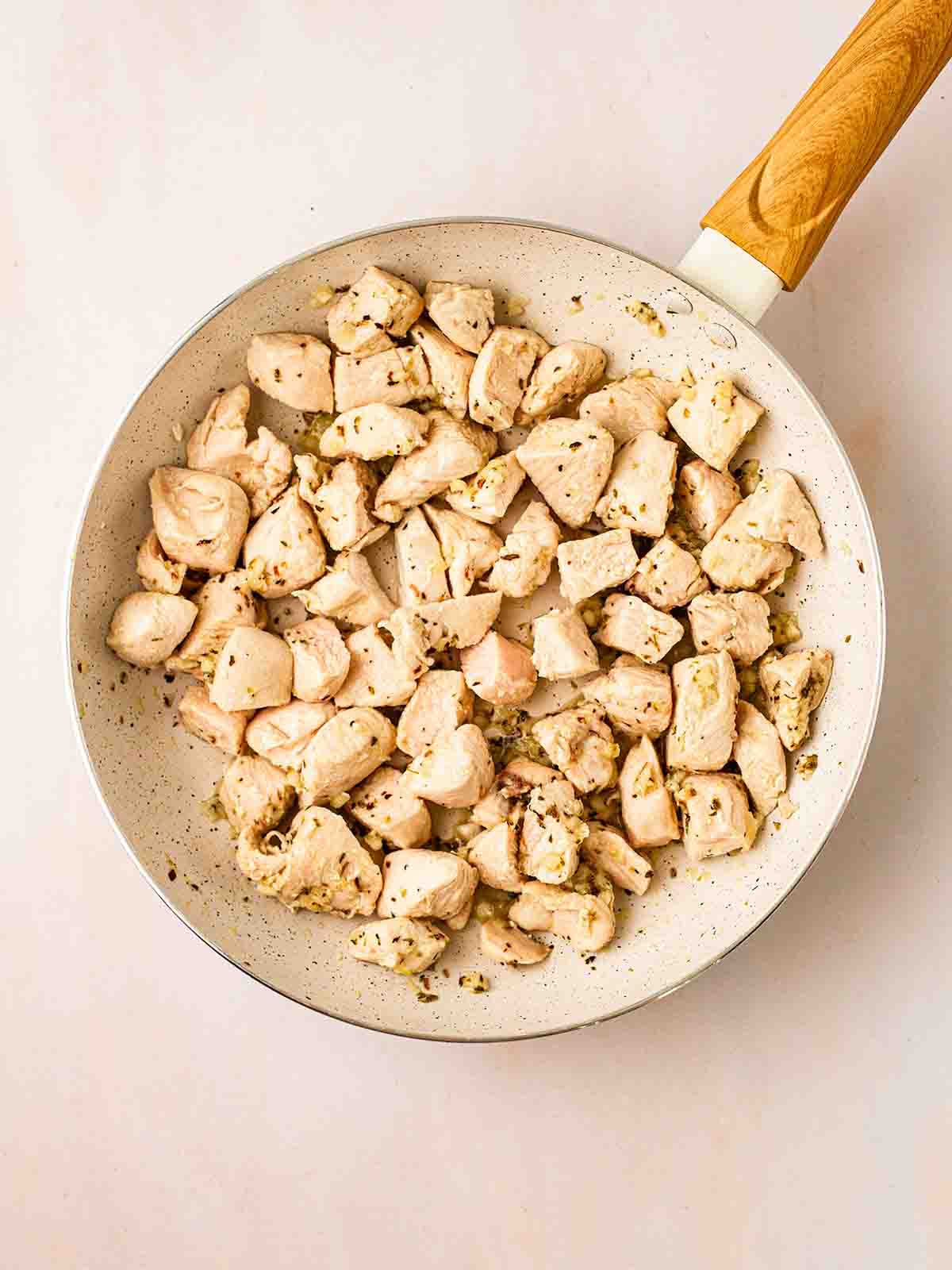 Diced cooked chicken in a pan for step 1 in the process for Lemon Chicken Orzo recipe.