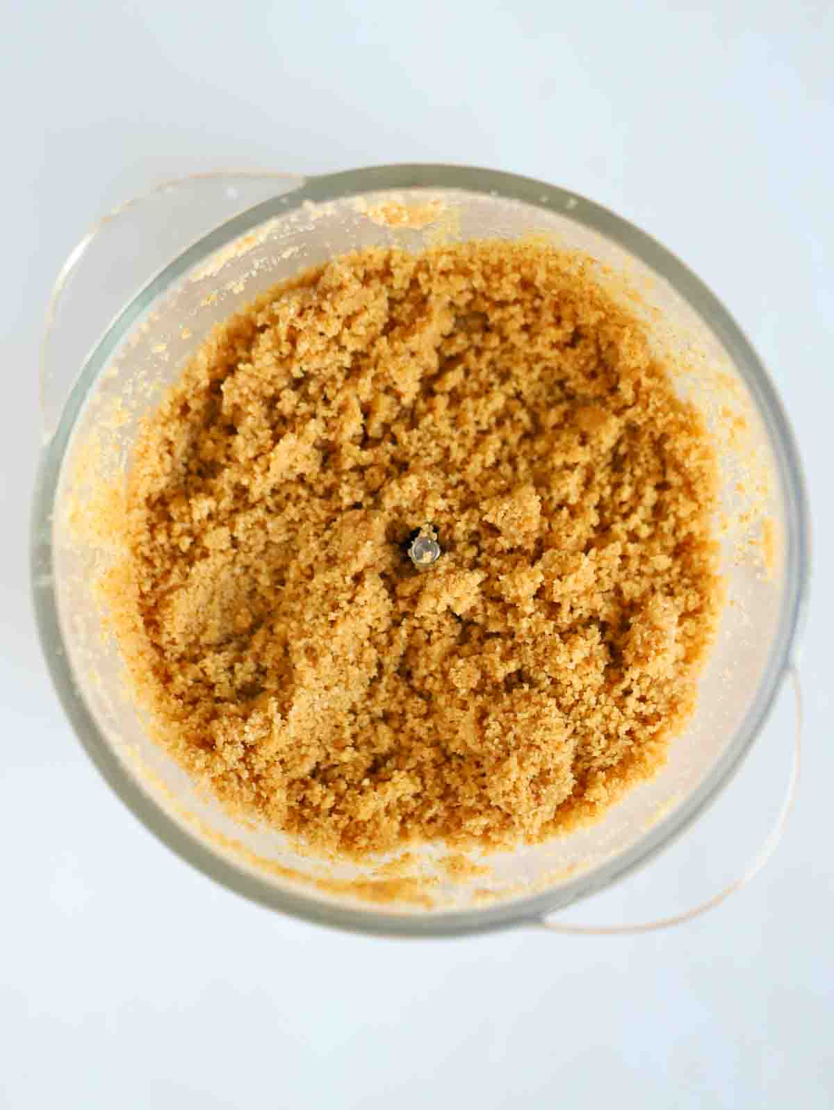 Crushed biscuit in a food processor for step 1 in the recipe for Nutella Cheesecake.